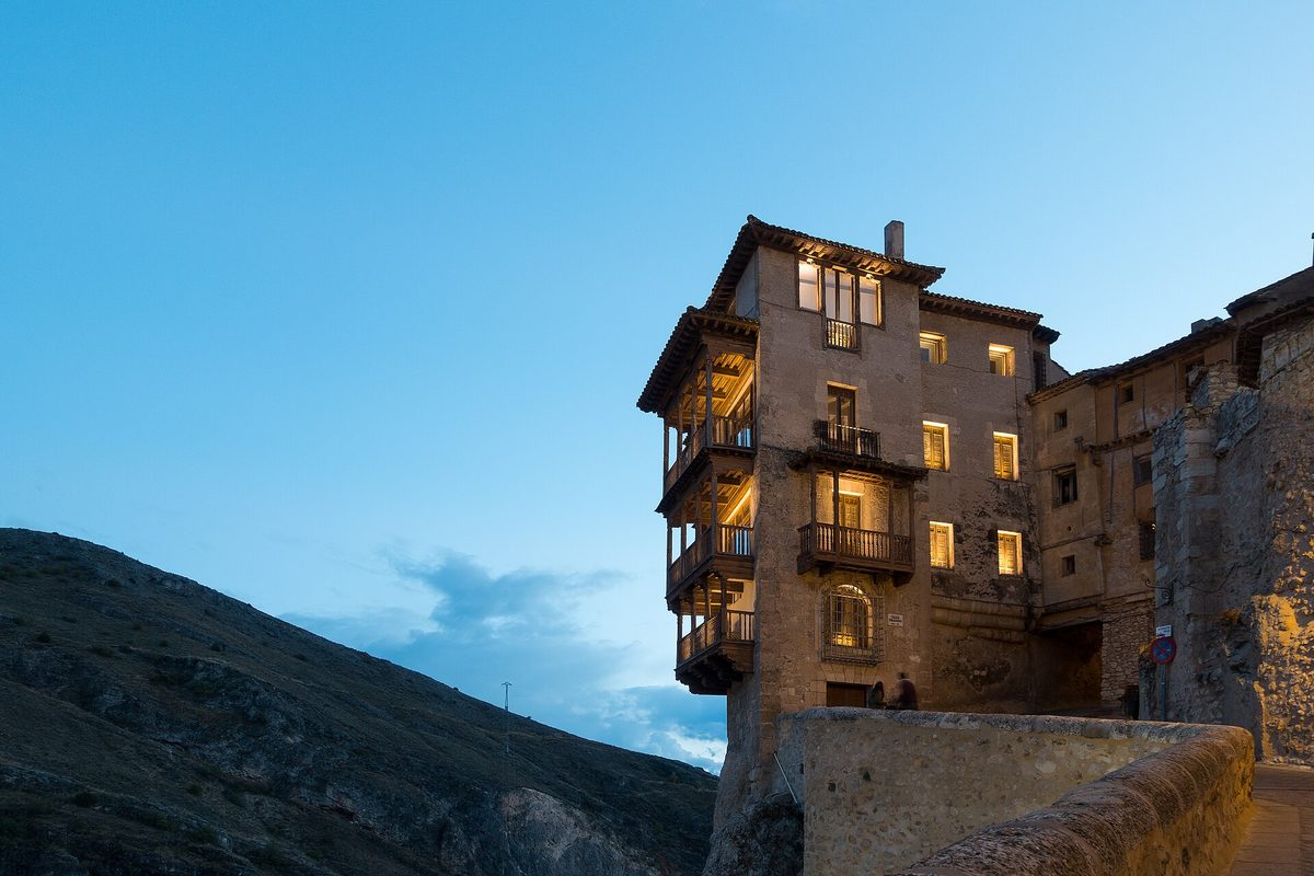Casas Colgadas de Cuenca al anochecer, con sus balcones de madera sobre la hoz del Huécar